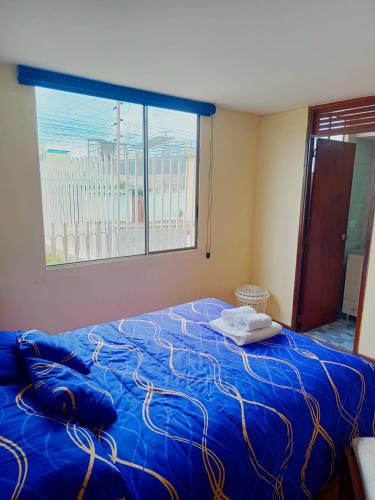 a bedroom with a blue bed with a window at Apartamento El Eden cerca Embajada Americana y Solca in Quito