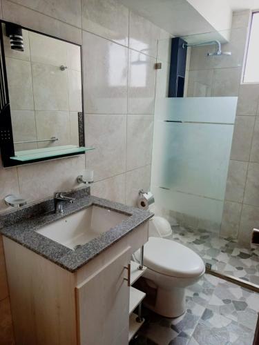 a bathroom with a sink and a toilet at Apartamento El Eden cerca Embajada Americana y Solca in Quito