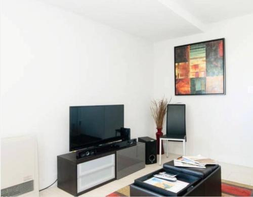 a living room with a flat screen tv at Beautiful Downtown & Bay Bridge, Vineyard Views! in San Francisco