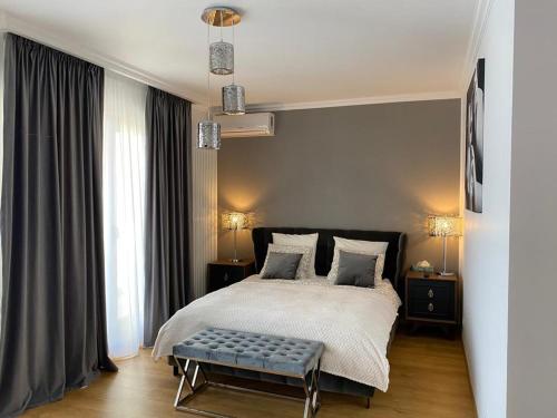 a bedroom with a large bed with a bench in it at Centenar Diamond in Ploieşti