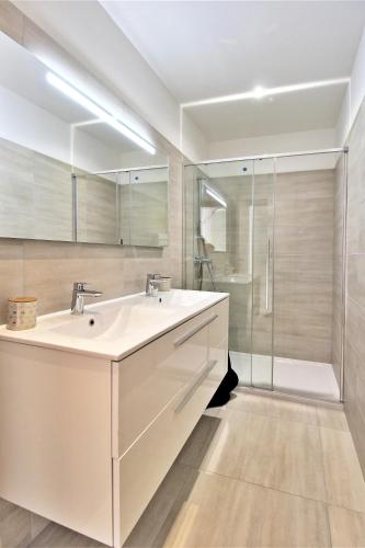 une salle de bain avec un lavabo blanc et une douche dans l'établissement Villa PIETRA 300m de la plage de Favone Piscine privée chauffée, à Conca