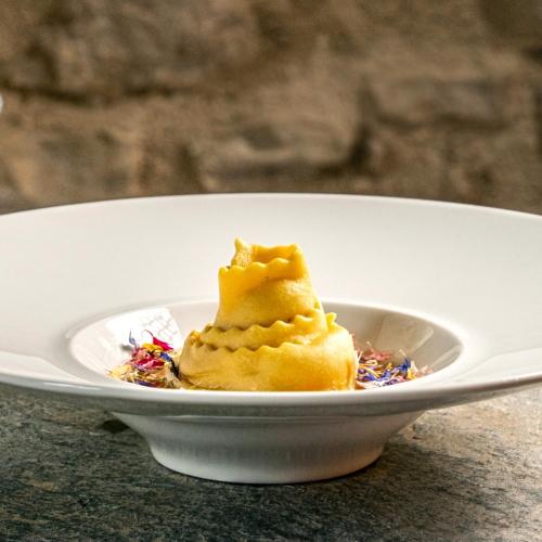 a white bowl with a piece of food in it at Monastero Sant'Alberico Relais in Balze