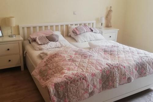 a bed with a pink and white quilt and pillows on it at Penthousewohnung 120 qm Innenstadt+ Dachterrasse in Bremen