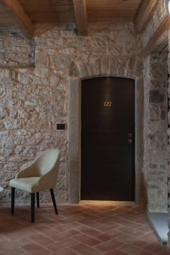 a chair in a room with a black door at Monastero Sant'Alberico Relais in Balze