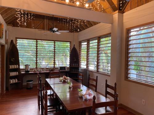 comedor con mesa de madera y algunas ventanas en Hotel Guanaja, en Guanaja