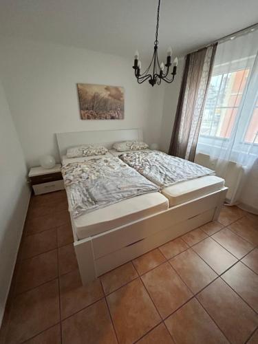 łóżko w sypialni z żyrandolem w obiekcie Haus Jasmund Ferienwohnung 1 w mieście Binz