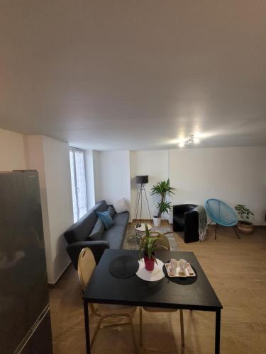 un salon avec un canapé et une table dans l'établissement Appartement privé à 15mn de Paris et proche Enghien les bains, à Groslay