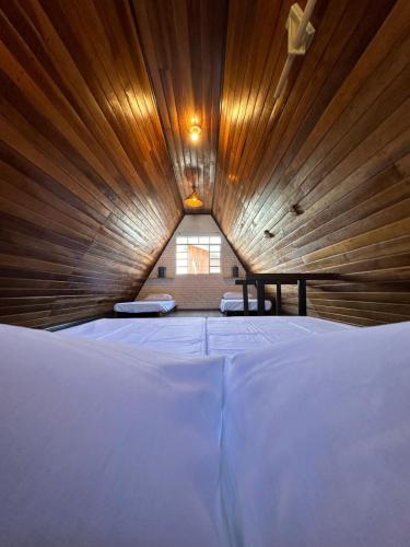 uma cama grande num quarto com tecto em madeira em Chale Bombinhas/Borto Belo em Porto Belo