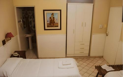 1 dormitorio con 1 cama y una foto en la pared en Hotel Nuevo CASABLANCA en Salta