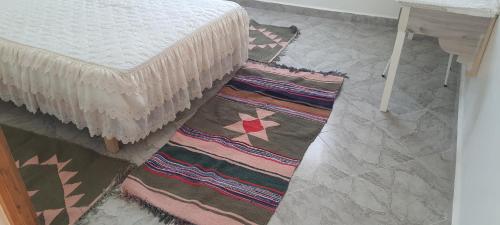 a room with two rugs on the floor next to a bed at Dar souade chatt mariem in Sousse