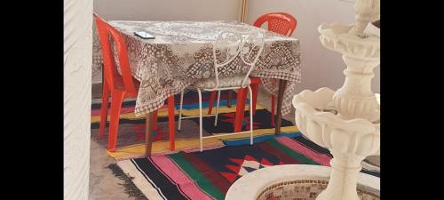 a table with chairs and a table with a table cloth on it at Dar souade chatt mariem in Sousse