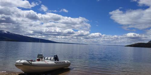 a boat sitting on the shore of a lake at Casa Pampa in Sarmiento