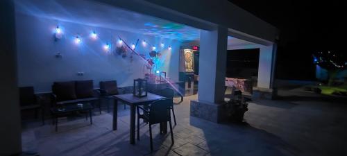 a living room with a table and lights on the wall at Casa rural con piscina climatizada y barbacoa a 10 km de Alicante y playas, 3000 m2 de terreno in Elche