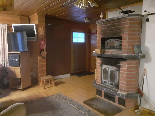 a living room with a brick fireplace in a house at Rauhallinen mökki in Lahti
