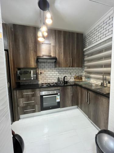 a kitchen with wooden cabinets and a stove top oven at Onelove Homes in Lusaka