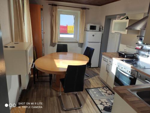 a kitchen with a wooden table and a table and chairs at Nice small house in beautiful Carinthia in Feistritz im Rosental