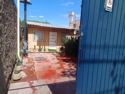 a blue door to a house with a driveway at Casa VillaOliva in Ciudad Lujan de Cuyo