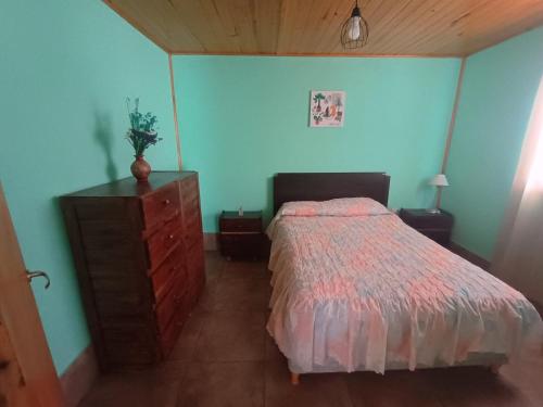 um quarto com uma cama e uma cómoda em madeira e uma cómoda com em Casa VillaOliva em Luján de Cuyo