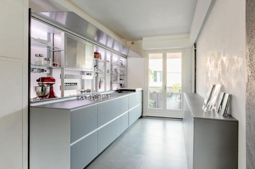 a large kitchen with white cabinets and a large window at luxury apartment in Pesaro