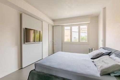a white bedroom with a bed and a window at luxury apartment in Pesaro