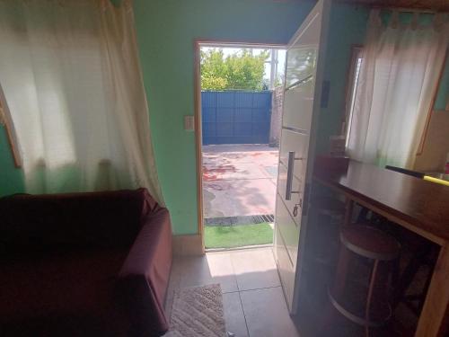 a living room with a couch and a door to a yard at Casa VillaOliva in Ciudad Lujan de Cuyo