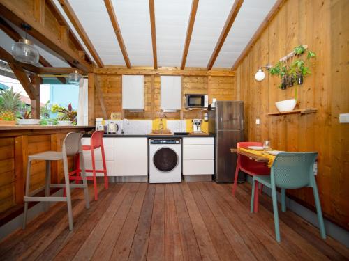 a kitchen with wooden floors and a table and chairs at Bungalows Ti Lodge Martinique - près de la plage avec jacuzzi privé in Sainte-Luce