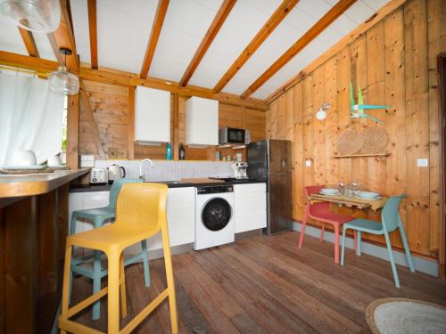 a kitchen with wooden walls and a table and chairs at Bungalows Ti Lodge Martinique - près de la plage avec jacuzzi privé in Sainte-Luce