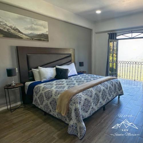 a bedroom with a bed and a large window at Hotel Santa María in Taxco de Alarcón