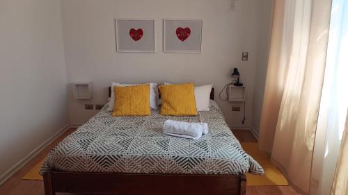 um quarto com uma cama com almofadas amarelas em Borde lago I - II -III em Puerto Varas