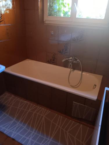 a bath tub with a shower in a bathroom at Ländlezimmer in Rankweil