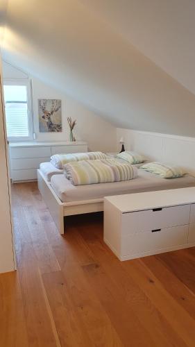 a white bedroom with a large bed and a window at Ferienwohnung Weitblick in Offenburg