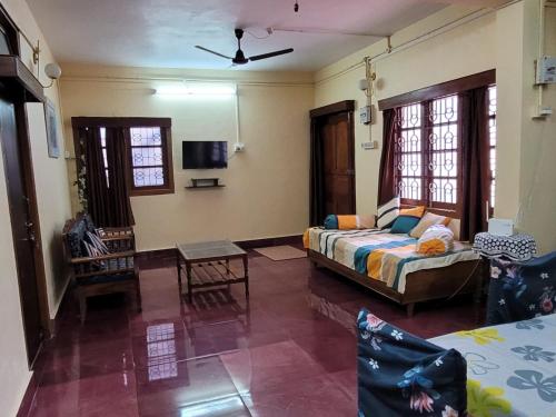 a living room with a bed and a couch at Sea Edge Homestay in Port Blair
