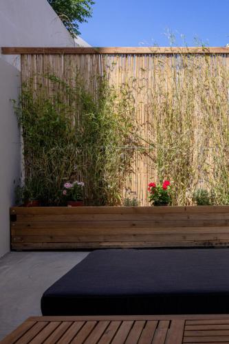 a yoga mat on a wooden bench in front of a fence at Raffar luxury houses in Tinos Town