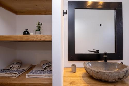 a bathroom with a bowl sink and towels at Raffar luxury houses in Tinos Town
