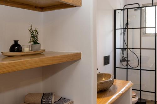 a kitchen with a counter with a bowl on a shelf at Raffar luxury houses in Tinos Town