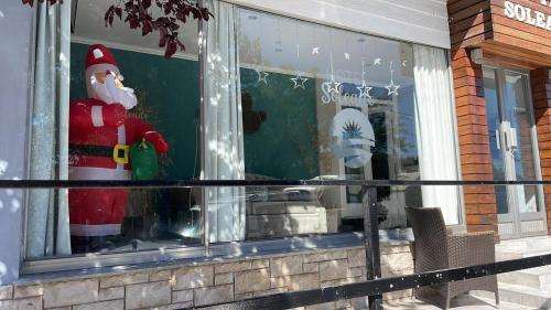 una ventana de Navidad de una tienda con una cláusula Santa en ella en HOTEL SOLEADO MH en Monte Hermoso