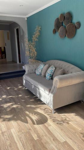 un sofá en una sala de estar con una pared azul en HOTEL SOLEADO MH en Monte Hermoso
