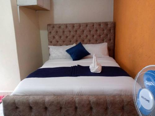 Atiram furnished apartments في ناكورو: غرفة نوم بسرير كبير ومخدات زرقاء وبيضاء