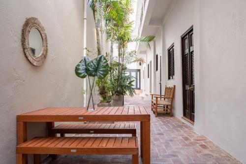 聖胡安的住宿－Tizol Historic Building 8br in Old San Juan，木凳坐在走廊上,种植着植物
