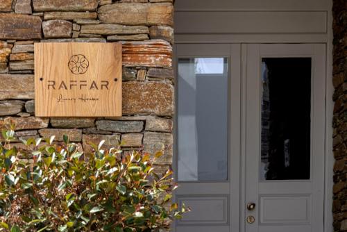 a sign on a stone wall next to a door at Raffar luxury houses in Tinos Town