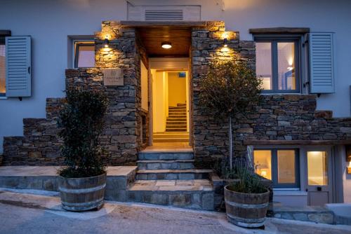 a stone house with a yellow door and lights at Raffar luxury houses in Tinos Town