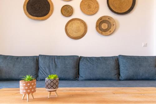 a blue couch with hats hanging on a wall at Raffar luxury houses in Tinos Town