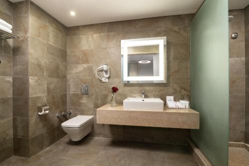 a bathroom with a sink and a toilet and a mirror at Dhara Residence E2 Lodge Hotel in 6th Of October