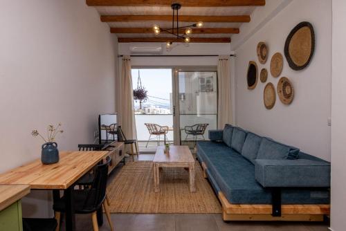 a living room with a blue couch and a table at Raffar luxury houses in Tinos