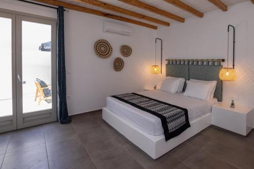 1 dormitorio con 1 cama y puerta corredera de cristal en Raffar luxury houses en Tinos Town