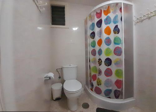 a bathroom with a toilet and a colorful wall at Paraiso in Tacoronte