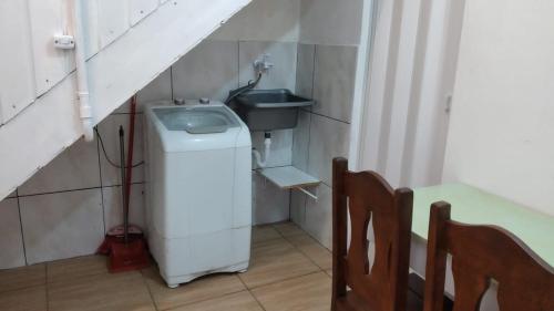 a small bathroom with a sink and a washing machine at Kitnet Avenida in Imbituba