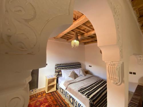 a bedroom with a bed and an archway at Tafsut dades guesthouse stay with locals in Tamellalt