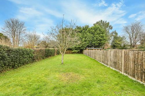 a tree in a yard next to a fence at Moselle House in Biggin Hill