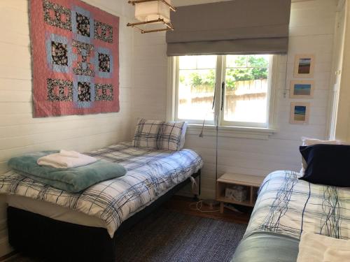 Zimmer mit 2 Betten und einem Fenster in der Unterkunft Kimberley Blue West Wing Sunny Decks Cosy Fire in Blackheath